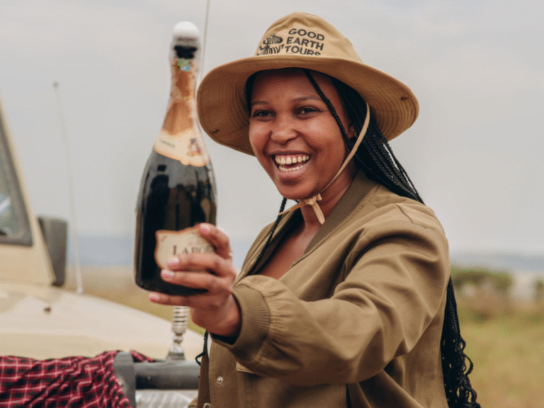 Guest celebrating with champagne after a game drive on a luxury all inclusive African safari.