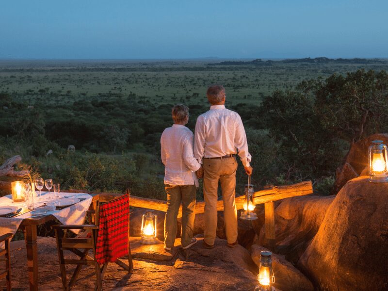 Why a Safari for Couples is the Ultimate Romantic Escape 1 couple looking over the Tanzania landscape at their bush dinner