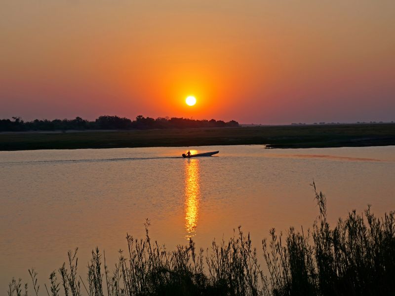 9 Best Countries in Africa for Safari: Where to Go for Epic Wildlife Adventures 4 wide shot of the chobe river and a boat gliding by at sunset