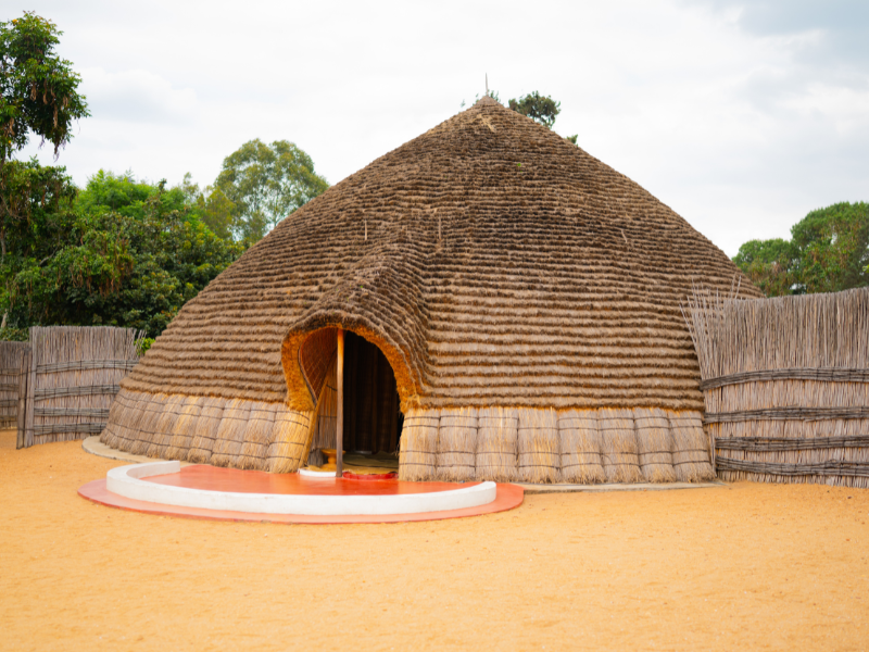The traditional Rwandan King’s Palace in Nyanza, featuring a reconstructed royal hut made from woven grass and surrounded by a bamboo fence.