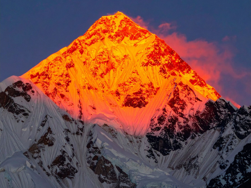 Kilimanjaro vs Everest Base Camp: Which Trek Should You Choose? 3 Golden morning light illuminating the distant snow-covered Himalayas, with clouds drifting low across the valley.