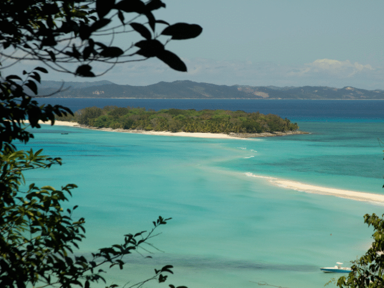 Turquoise waters and white sandy beaches surrounding Nosy Be island in Madagascar, a tropical paradise known for snorkeling and coral reefs.
