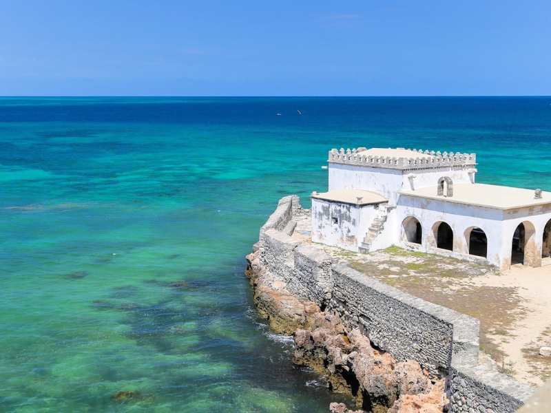 Historic whitewashed stone fort overlooking the turquoise ocean on Ilha de Moçambique, a UNESCO World Heritage site.