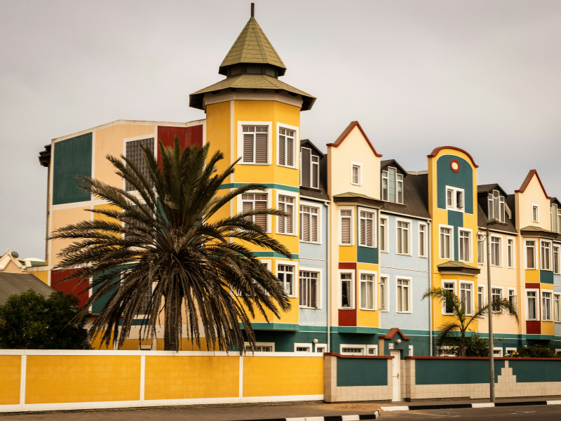 Colorful colonial-style buildings and palm trees in Swakopmund, Namibia’s coastal town known for its German architecture and seaside charm.
