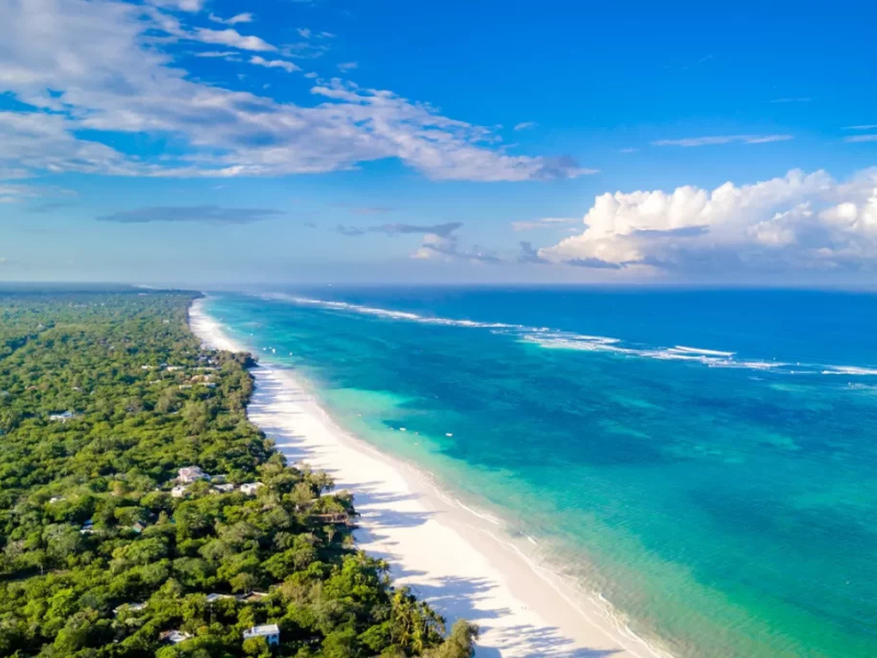 Aerial view of Diani Beach showing white sand, turquoise ocean and lush green coastline.