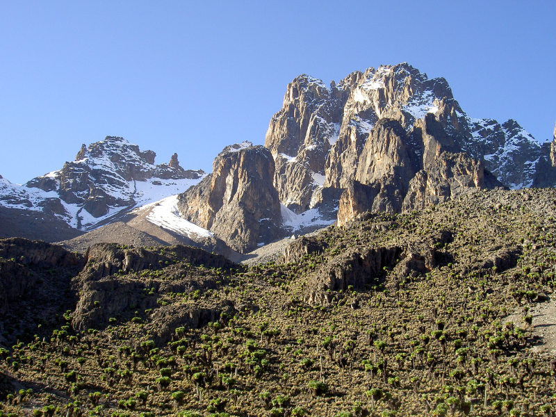 Towering snow-capped peaks of Mount Kenya rising above rugged alpine terrain.