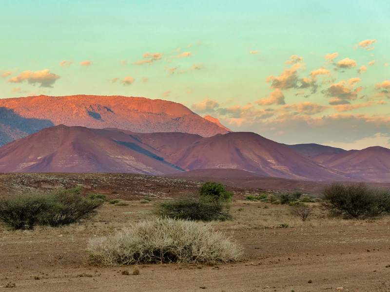 Sunset light glowing on the mountains and desert plains of Namibia’s Brandberg region.