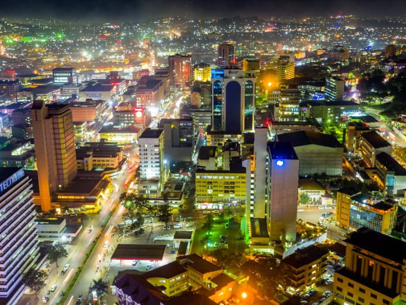 A bright nighttime view of Kampala’s skyline filled with colorful city lights.