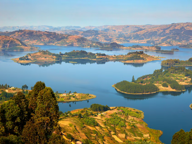 A scenic view of Lake Bunyonyi dotted with green islands and surrounded by rolling hills.