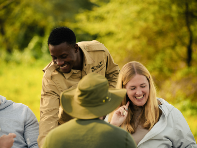 Lodge staff sharing a fun moment with guests, a reminder of why tipping on safari matters.