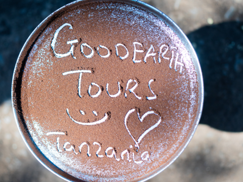 What to Expect on a Materuni Waterfalls & Coffee Tour (Tanzania Day Trip Guide) 3 A pan of coffee grounds with “Good Earth Tours Tanzania” written in it on a Materuni Waterfalls coffee tour.