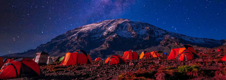 Kilimanjaro full moon climb campsite with glowing tents beneath a star filled night sky on Mount Kilimanjaro