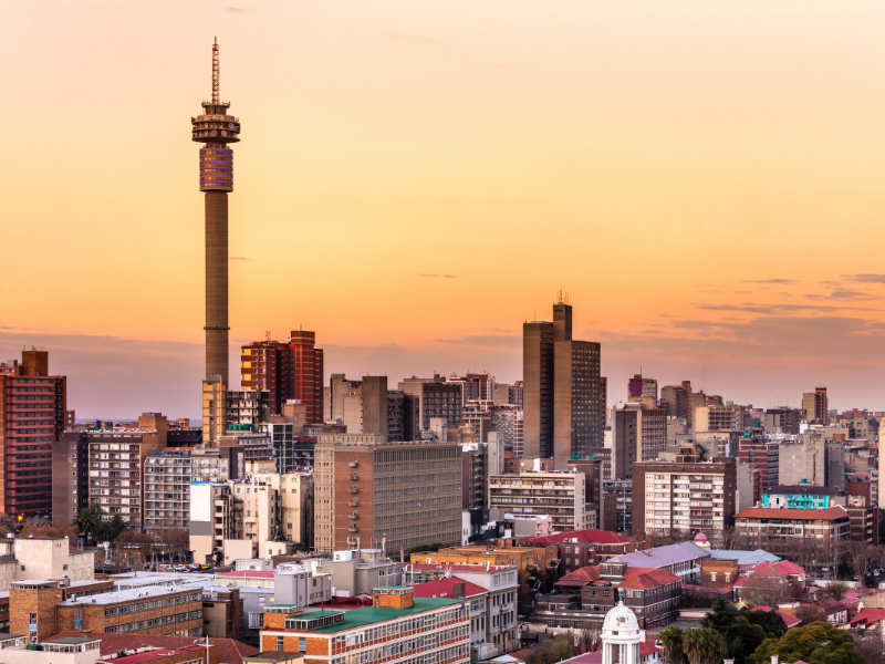 How to Get to Your African Safari Without Flying Through the Middle East 3 Johannesburg city skyline at sunset with the Hillbrow Tower, a major connecting hub for safari flights to Southern Africa
