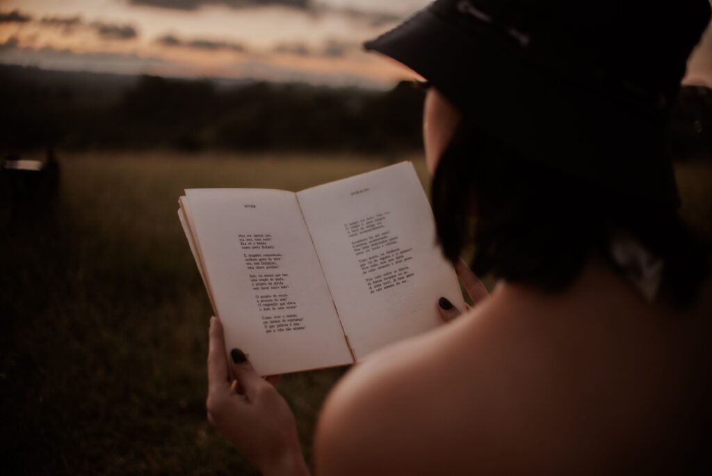 traveler sitting in camp chair reading at dusk, warm lantern light, open bush beyond the camp